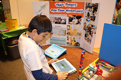 A student from “Team Shark” uses an app to program the team’s model.