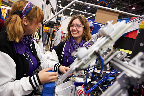 High school students work on their robot in the FIRST Robotics Competition pits at FIRST Championship.