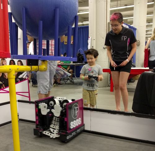 Rose encourages a young robot driver at a community outreach event.