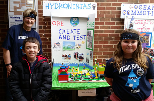 Students from a FIRST LEGO League Jr. team exhibit their Show Me poster and model at an expo in McLoud, Oklahoma.