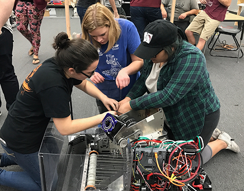 Melanie works with her teammates on a robot for Team 987 “High Rollers.”