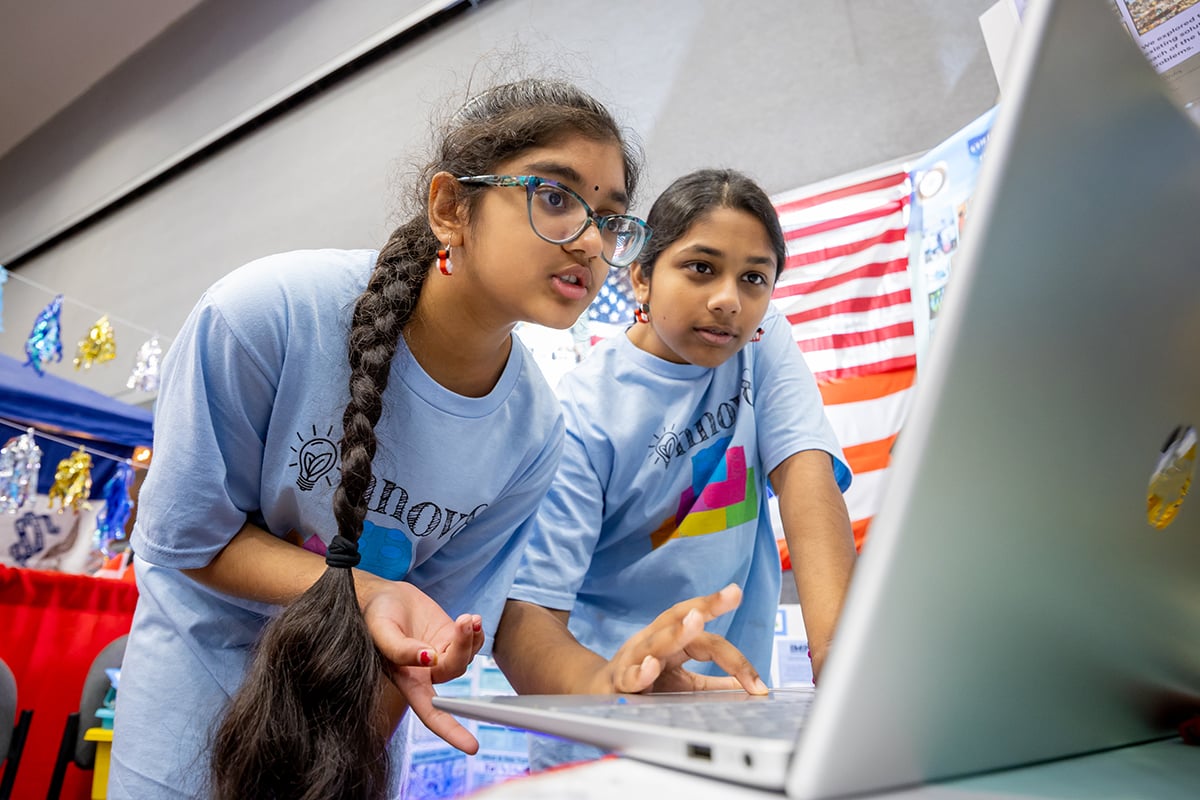 Two FIRST LEGO League students programming their robot at FIRST Championship.