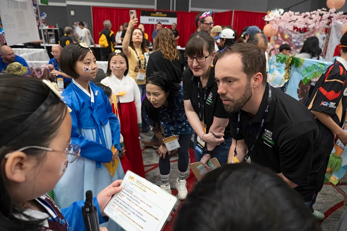 FIRST LEGO League team talking to event volunteers at 2026 FIRST Championship