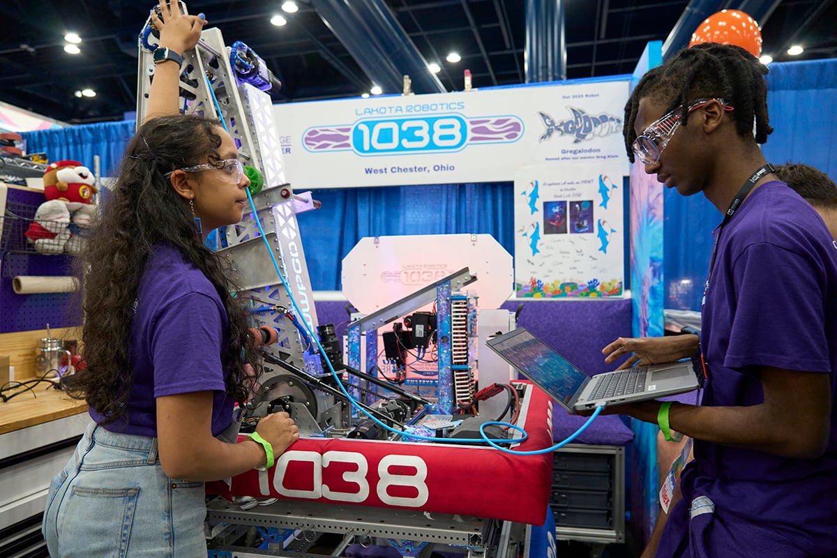 Two FIRST Robotics Competition students working on their robot at FIRST Championship