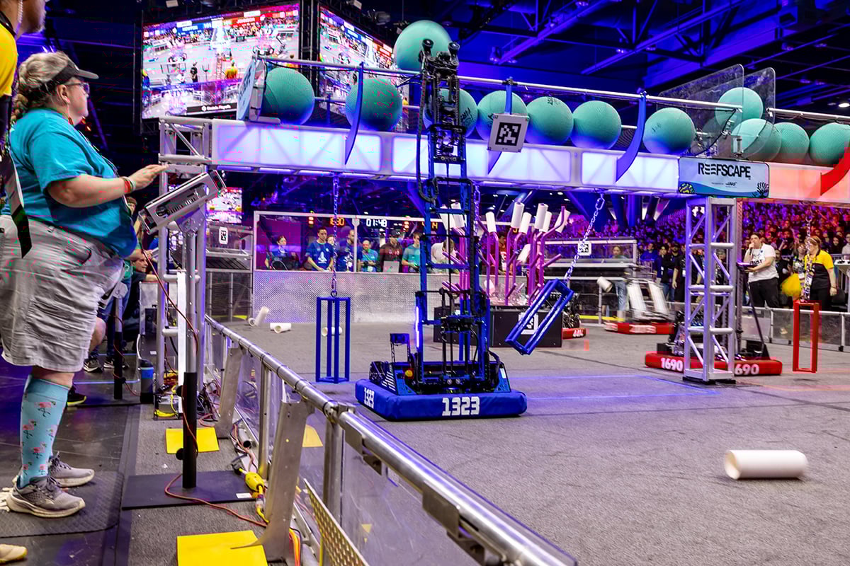 FIRST Robotics Competition robots scoring game objects at FIRST Championship