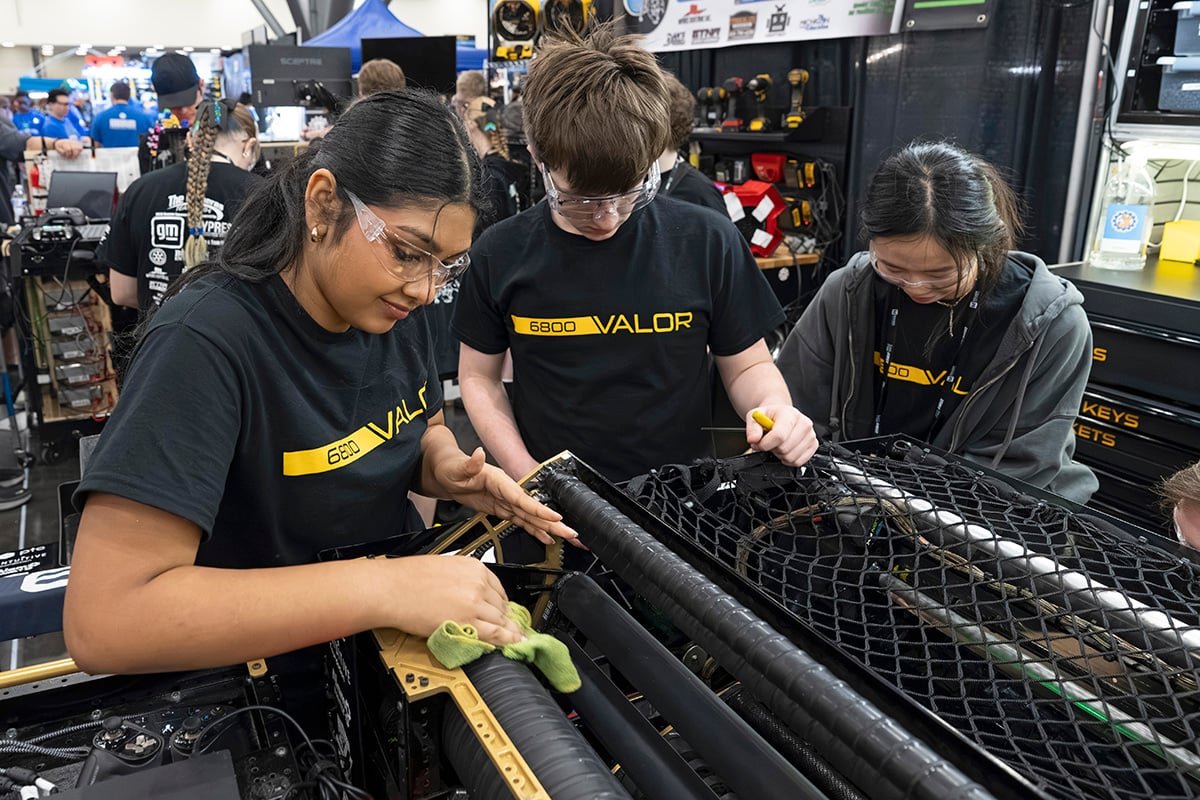 FIRST Robotics Competition student participants working on robot at 2026 FIRST Championship with help from mentor