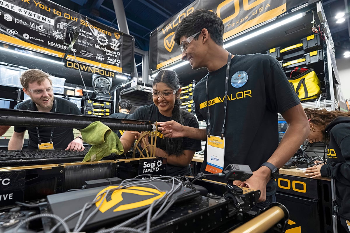 FIRST Robotics Competition student participants working on robot at 2026 FIRST Championship with help from mentor