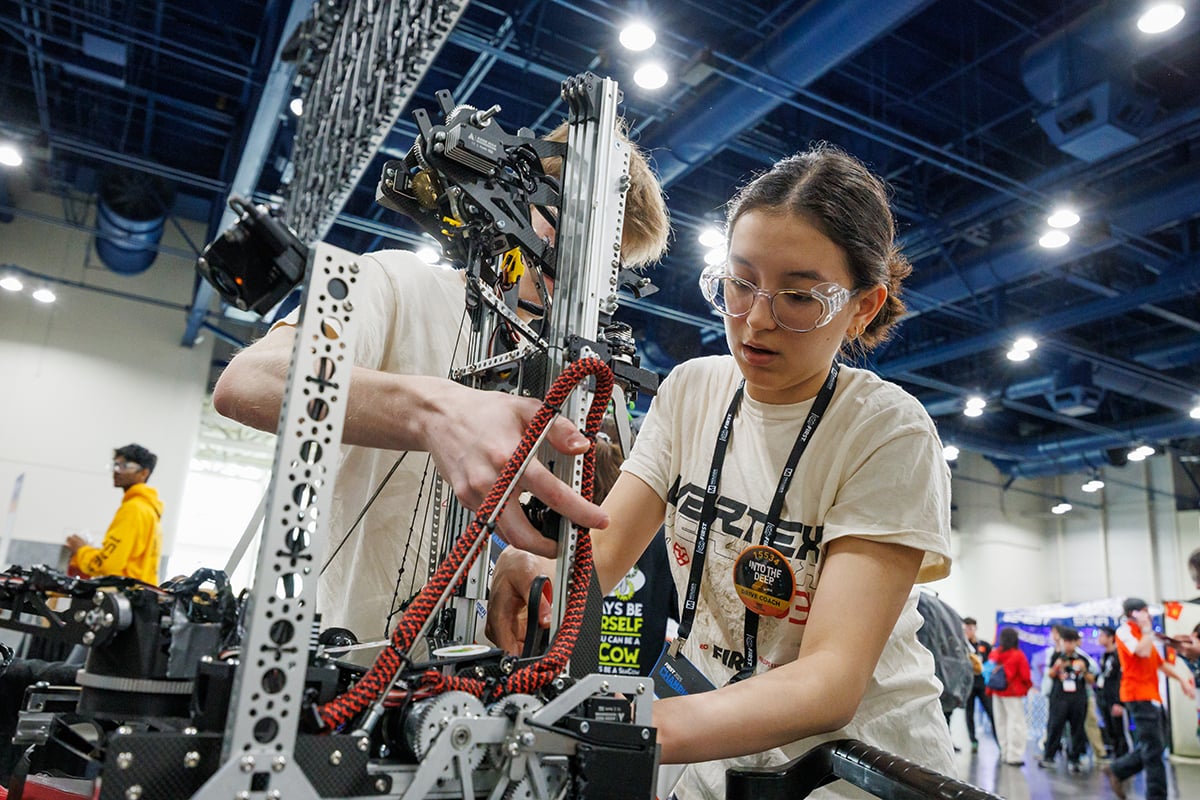 Two FIRST Tech Challenge students working on their robot at FIRST Championship