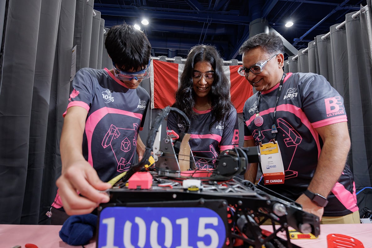 FIRST Tech Challenge students working on robots in pits at 2026 FIRST Championship with mentor help