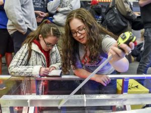 <em>FIRST </em>Robotics Competition student participants measure the field for the 2018 season game, FIRST POWER UP.