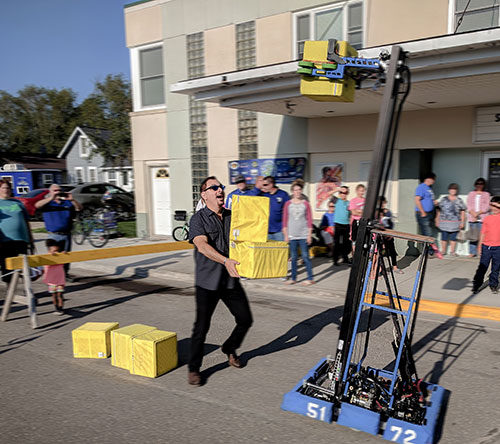 Director Joe Brandmeier stacks boxes with the team’s robot.