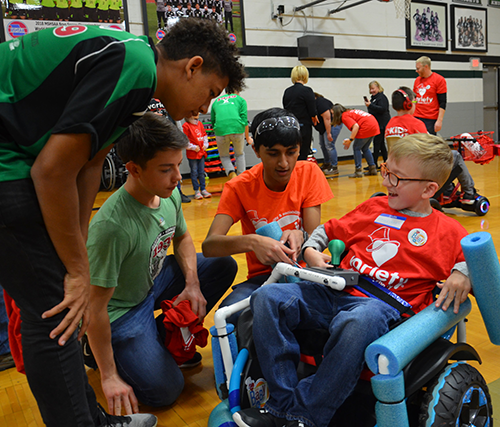 Sola Dugbo, Ryan Lang, and Aasim Hawa from The Kuhnigits make final adjustments to a FisherPrice WildThing the team hacked into a motorized wheelchair for Braeden, complete with a custom-designed joystick, at the team’s annual GoBabyGo - FIRST Community Build on November 23, 2019.