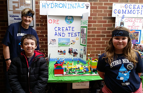 Students from a FIRST LEGO League Jr. team exhibit their Show Me poster and model at an expo in McLoud, Oklahoma.